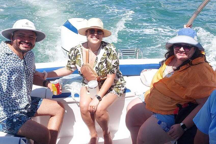 Trois personnes se trouvent sur un bateau, avec l’eau en arrière-plan. 4