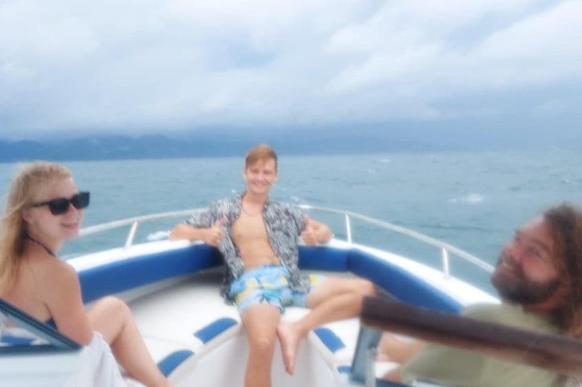 A boat with people on it, water, and a cloudy sky. 4