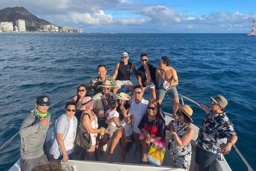 Un groupe de personnes se trouve sur un bateau, avec une vue sur la ville et un phare en arrière-plan. 3