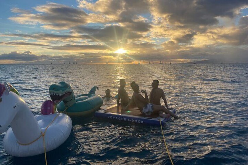 Un bote con juguetes inflables y un atardecer de fondo. 3