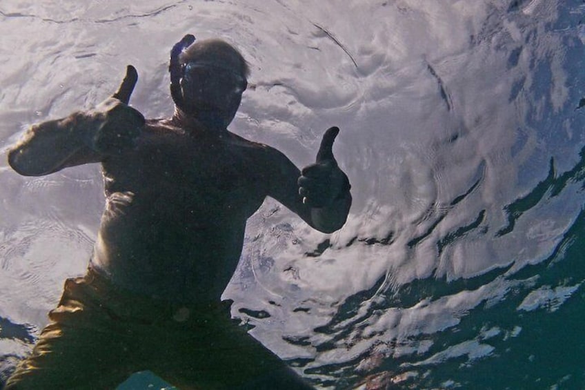A person swimming in the ocean with a wave. 2