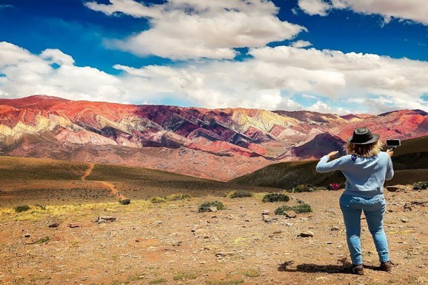 A person taking a photo of a colorful mountain range. 2
