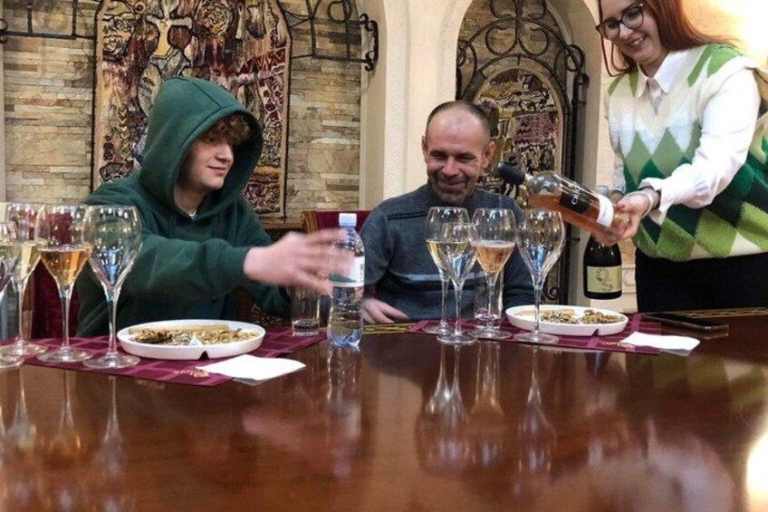 A dining table with wine glasses and a bottle being poured. 4