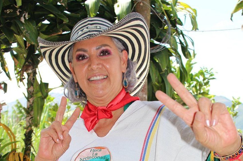 A person wearing a striped hat and a red bow tie, making a peace sign with their hands. 5