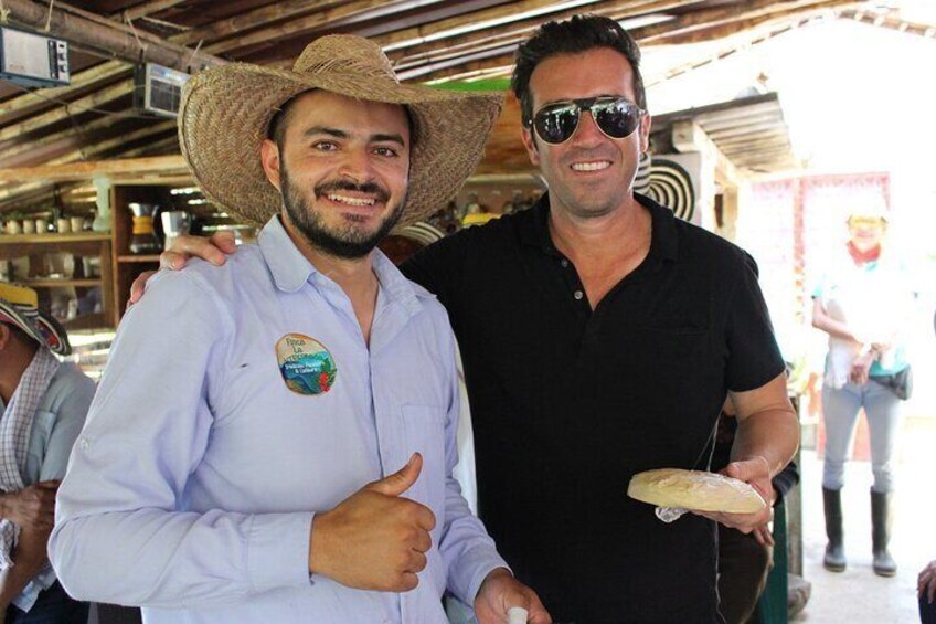 Two people at an outdoor market, one wearing a straw hat and the other holding a plate. 2