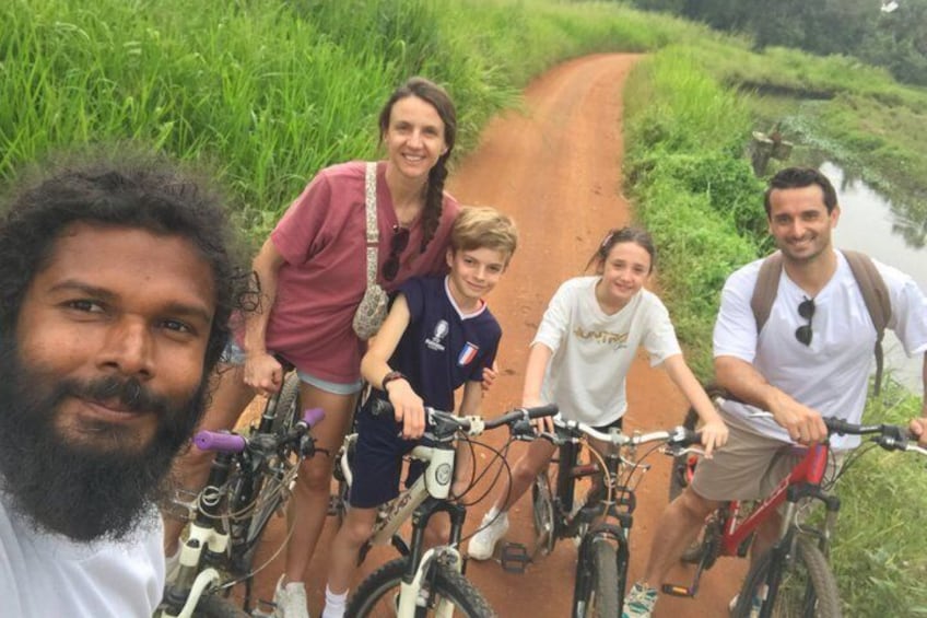 Un grupo de personas en bicicleta por un sendero de tierra rodeado de follaje. 1