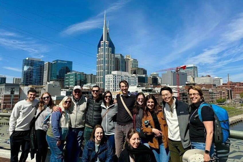 A group of people posing in front of a city skyline with a prominent skyscraper. 4