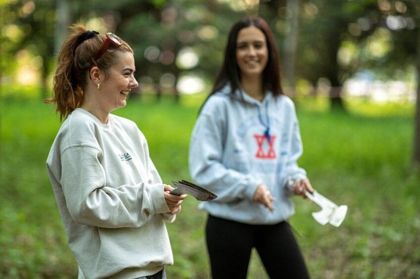 Two people in a park holding papers. 2
