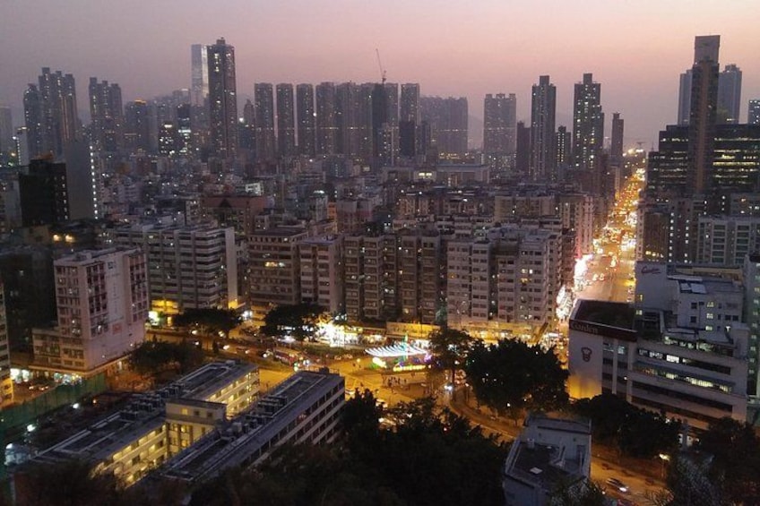 A cityscape at dusk with high-rise buildings, busy streets, and illuminated windows. 5