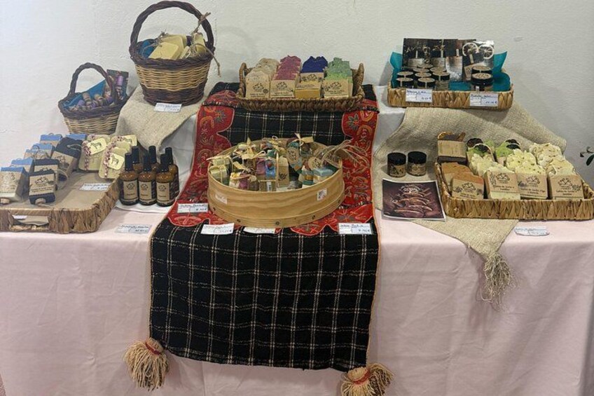 A display of various cheese and butter products on a table with a plaid cloth cover. 2