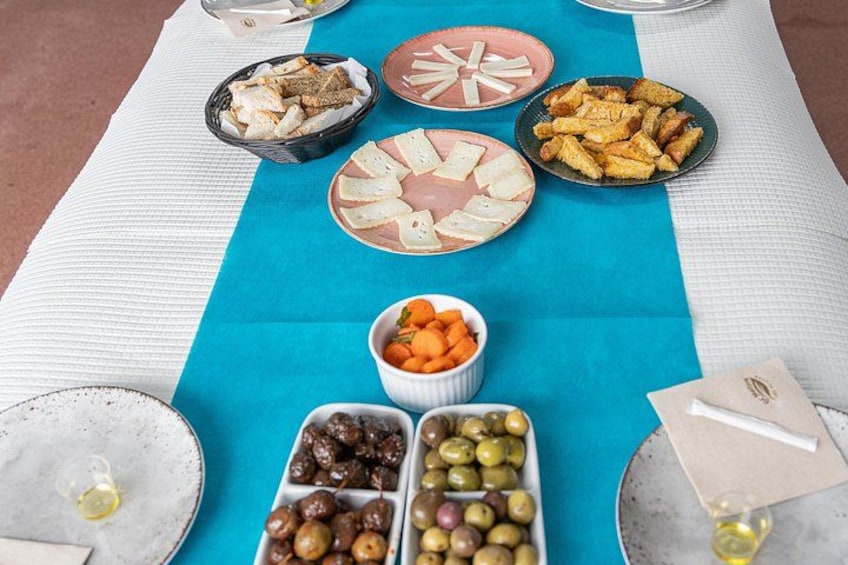 A table with various food items including olives, bread, and snacks. 4