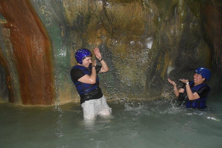 Dos personas en una cueva inundada con paredes rocosas. 3