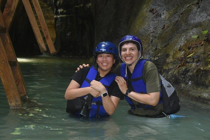 Dos personas con cascos y chalecos salvavidas en un cuerpo de agua con una estructura de madera. 4