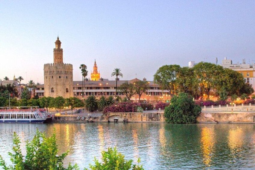 A river with a castle, a boat, and a cityscape with buildings and trees. 5