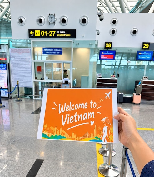 A sign with 'Welcome to Vietnam' and a person holding it. 5