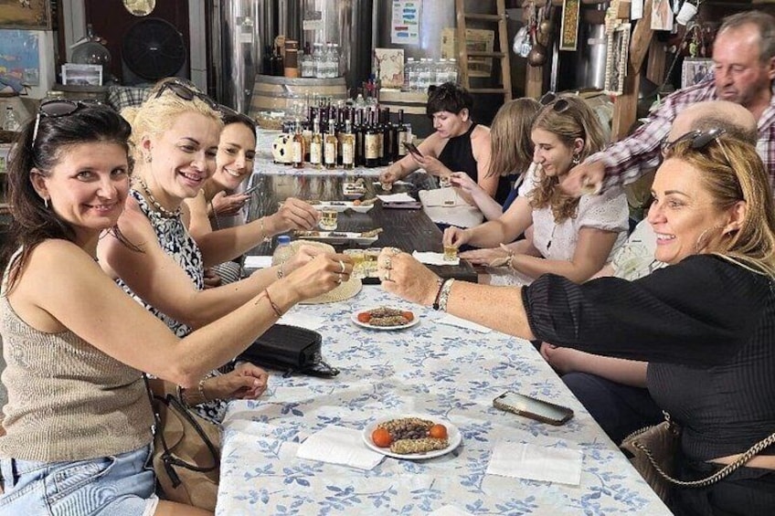 A group of people sitting at a table with food and drinks, in a restaurant setting. 2