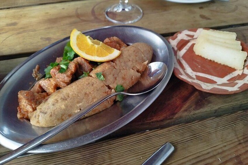 A plate of food with a lemon slice, a spoon, and a small dish with butter. 4