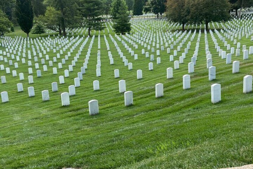 Un cimetière avec des rangées de pierres tombales blanches. 4