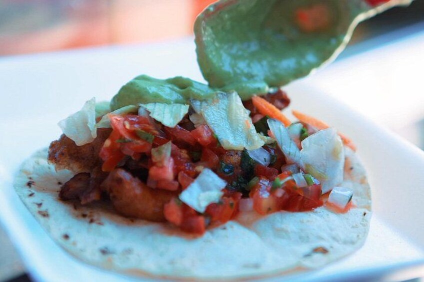 Un taco con salsa verde siendo servida encima. 2