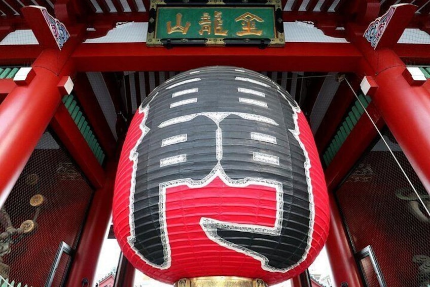 Un tradizionale torii giapponese con una lanterna rossa e nera appesa di fronte. 2