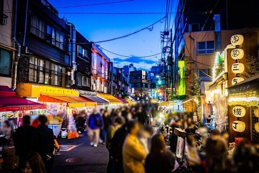 A bustling street market at dusk with people walking and vendors selling goods. 2