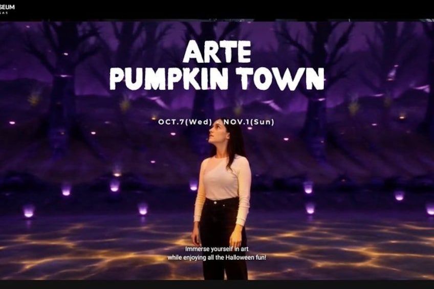 A person standing in a dark, tree-filled area with illuminated ground, with text indicating 'ARTE PUMPKIN TOWN' and dates 'OCT.7(Wed) NOV.1(Sun)'. 1