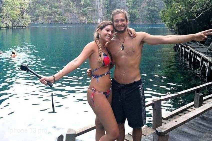 Una pareja en un muelle junto a un lago, con una pala en la mano. 4