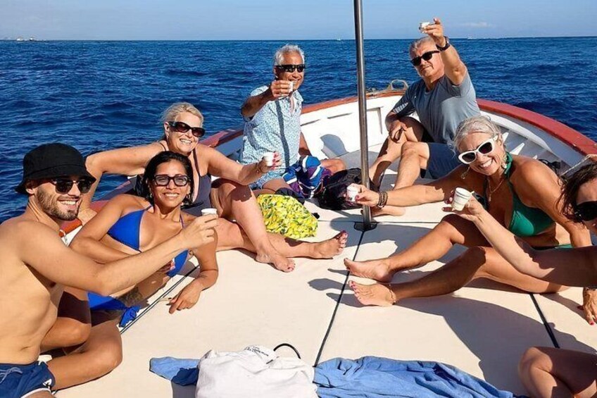 En gruppe mennesker på en båd med havet i baggrunden. 2