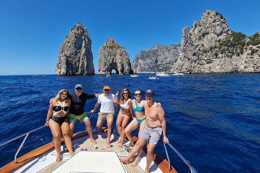 A group of people on a boat with a rocky coastline in the background. 1