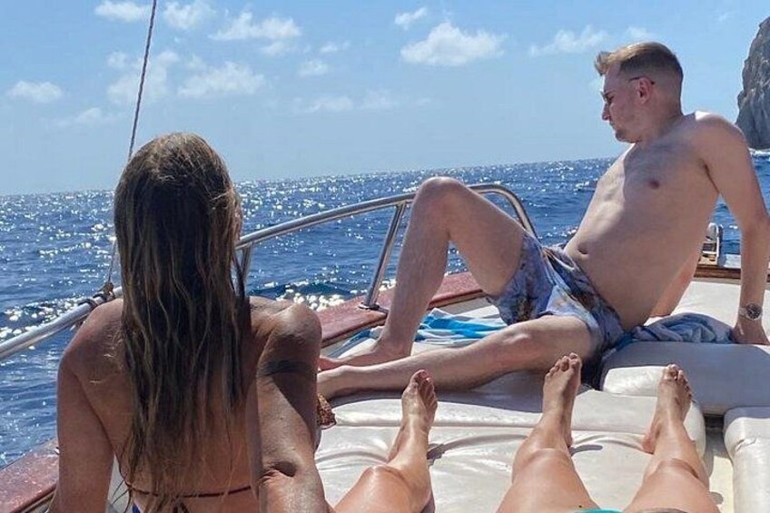 Two people relaxing on a boat with the ocean in the background. 3