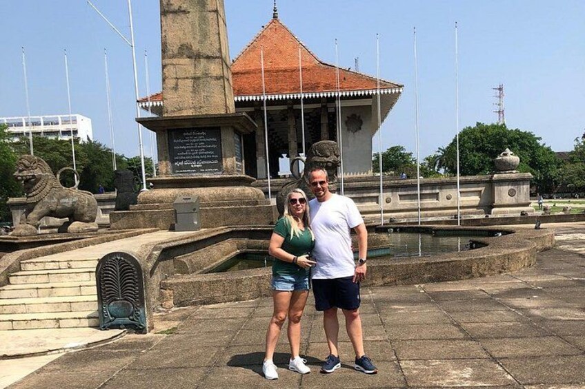 A monument with a lion statue, a tiled roof structure, and a fountain. 3
