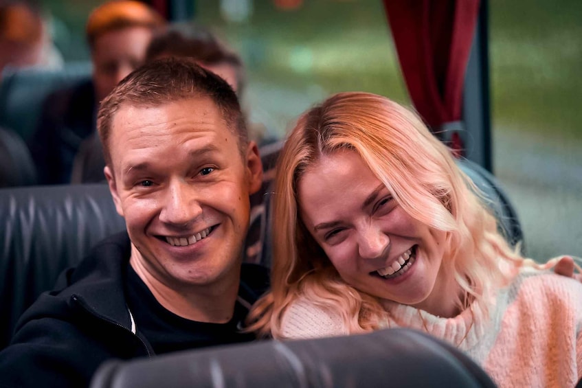Two people sitting closely together on a bus. 2