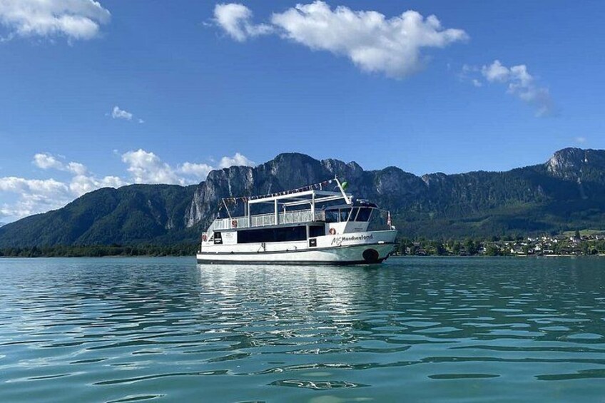 A boat on calm water with mountains in the background. 2