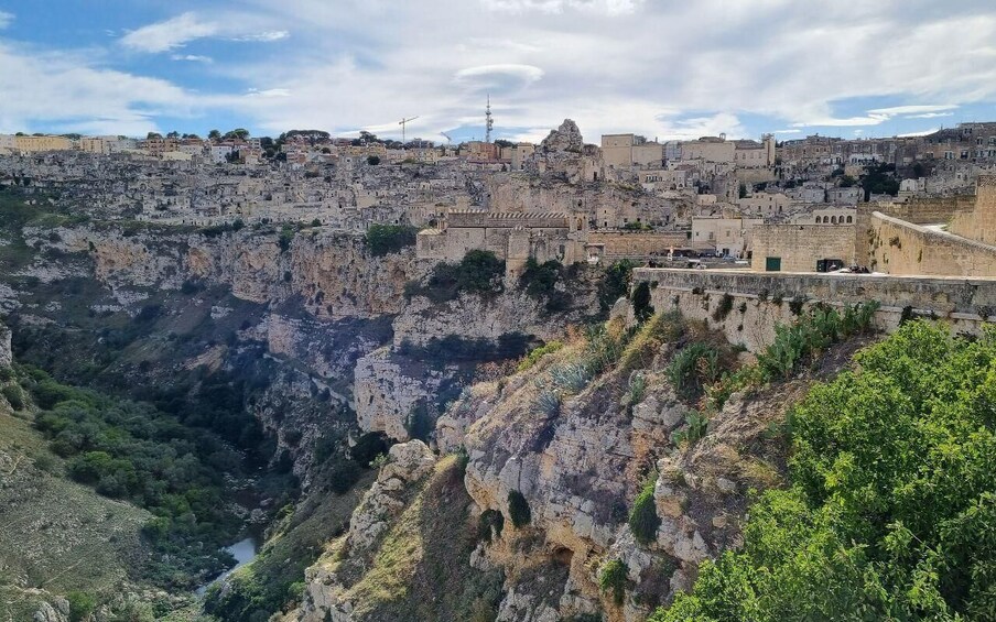 A rugged cliffside with a dense urban settlement at its base. 3