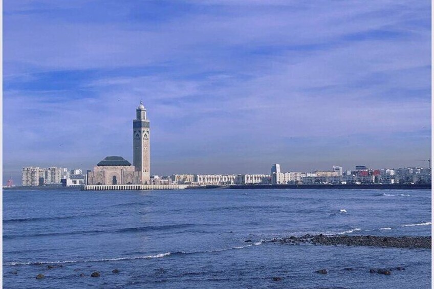 A coastal cityscape with a prominent tower and a mosque. 2