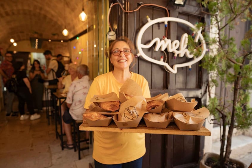 Une personne qui porte un plateau rempli de plats dans un restaurant. 4