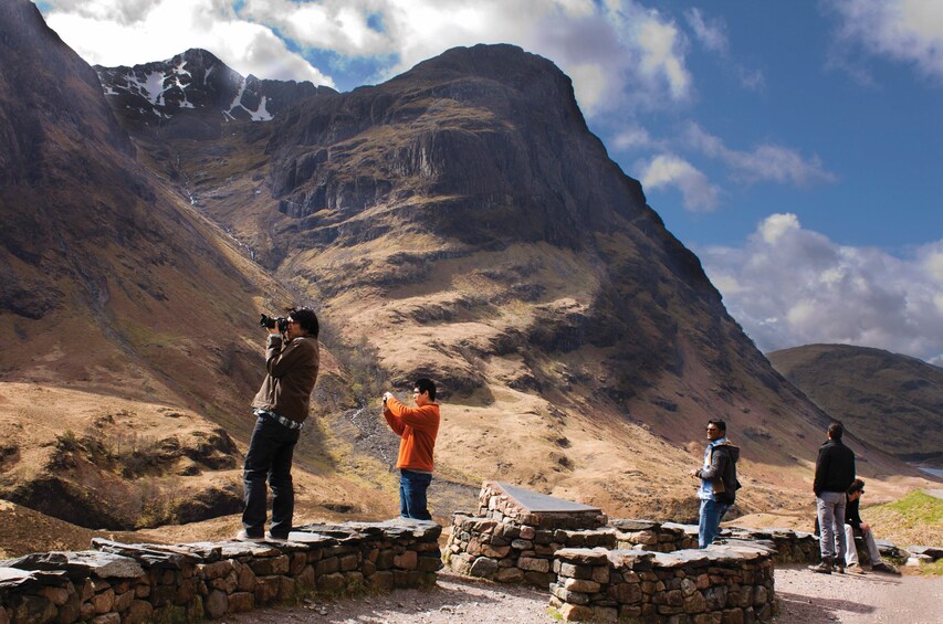 Un groupe de personnes prenant des photos d’un paysage montagneux. 4
