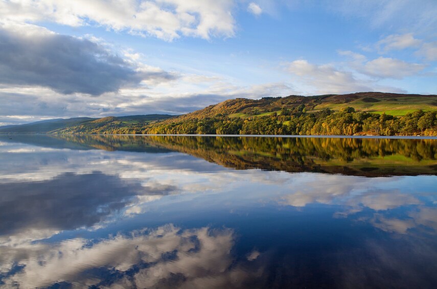 Un lac paisible qui reflète le ciel et les collines environnantes. 1