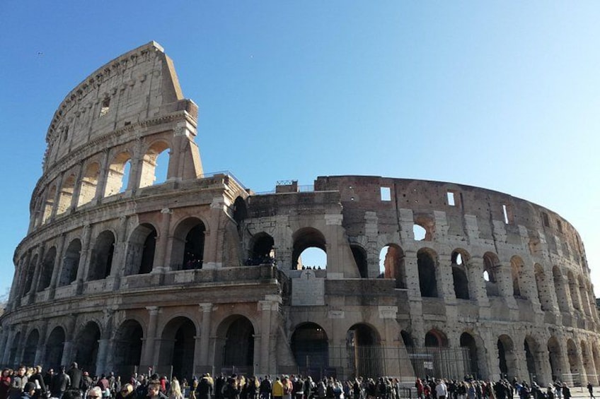 The Colosseum in Rome with visible arches and a crowd of people. 4
