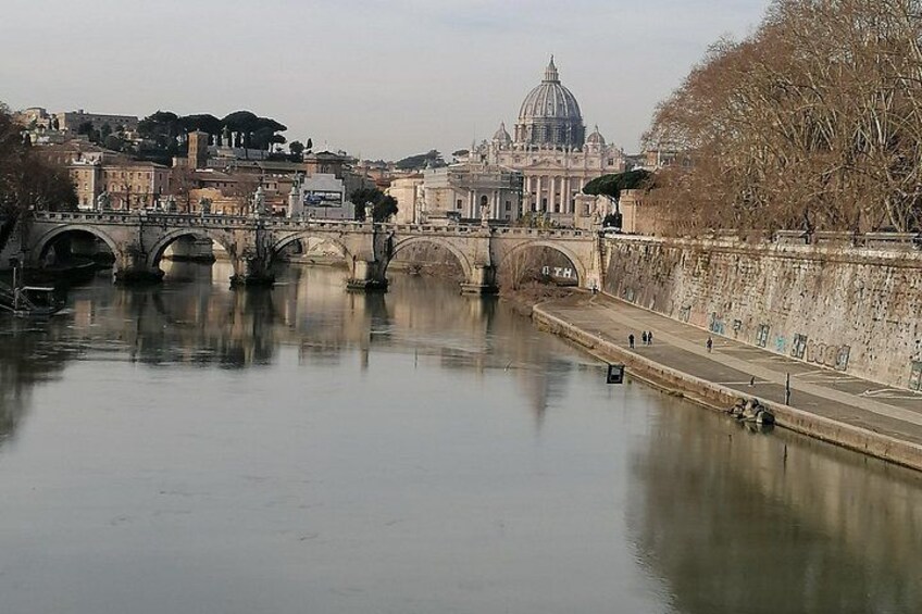 A river with bridges, a dome-shaped building, and a leafless tree. 2