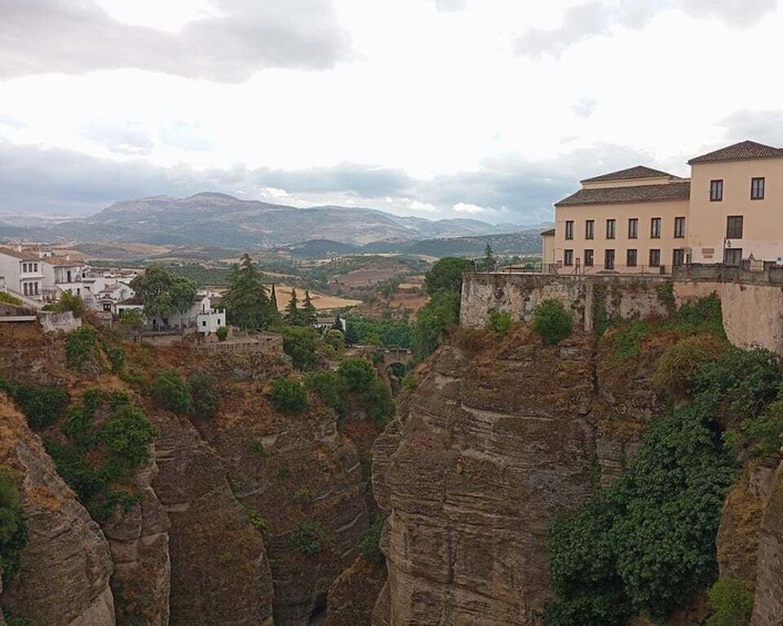 Paesaggio montuoso con edifici arroccati sulle scogliere, a picco su una valle. 5
