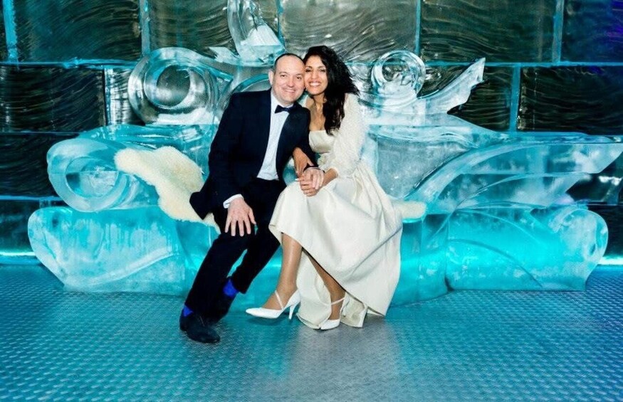 A couple posing in front of an ice sculpture. 3