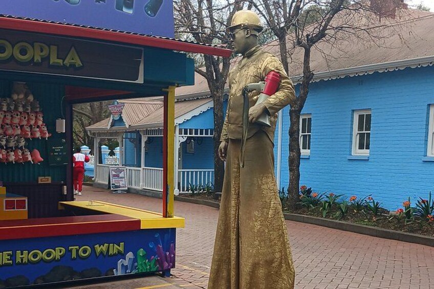 En blå bygning, en gylden statue og en farverig kiosk med skiltet 'HOOP TO WIN'. 5