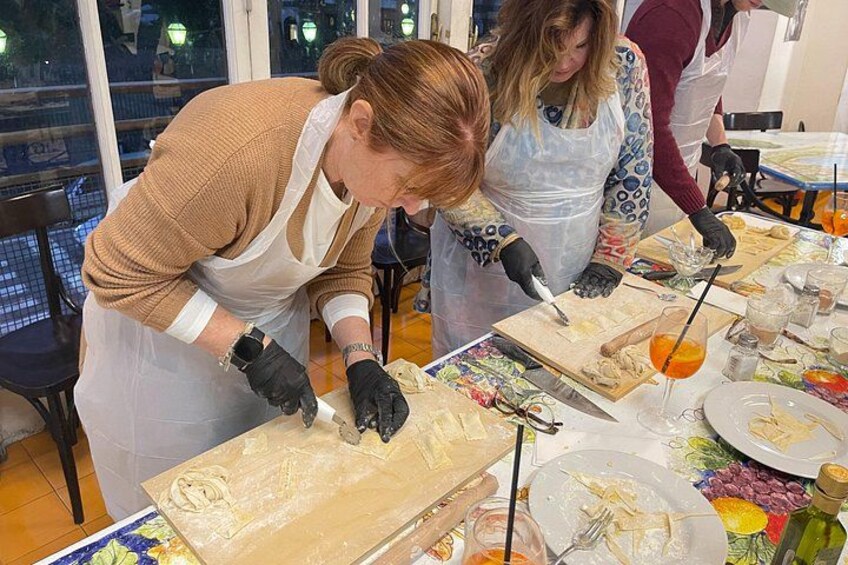 People preparing food at a table with various ingredients and utensils. 5