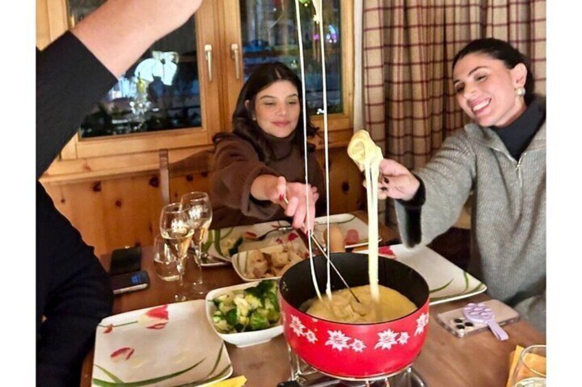 People at a table with a fondue pot. 5
