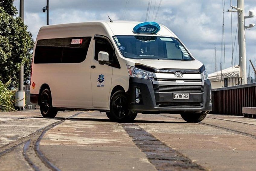 A white van with a blue license plate on a road. 2