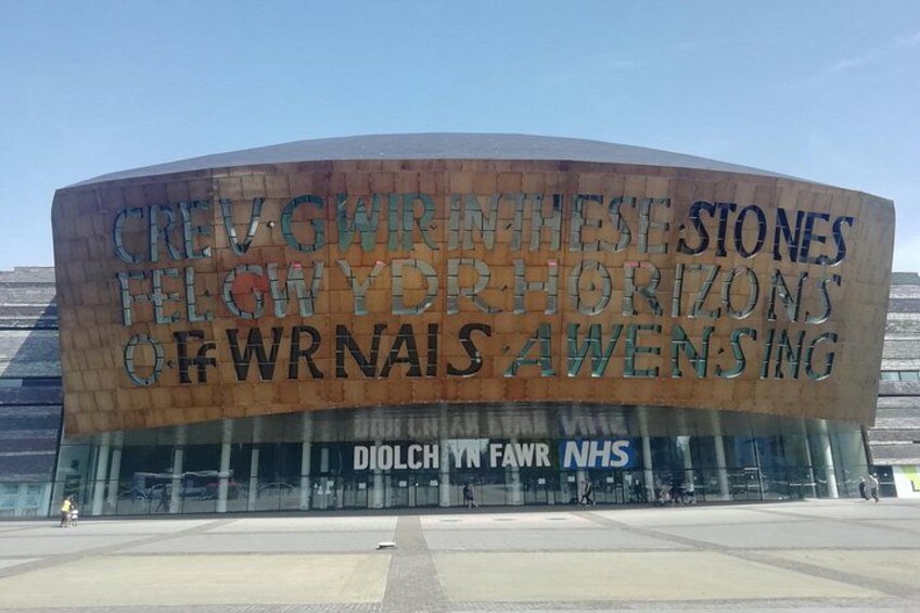 Een groot, gebogen gebouw met een bord waarop staat: 'CREWGRWNTHSTONES FOLLOW YOUR HORIZONS OF WRNALS AWENSING.' 5