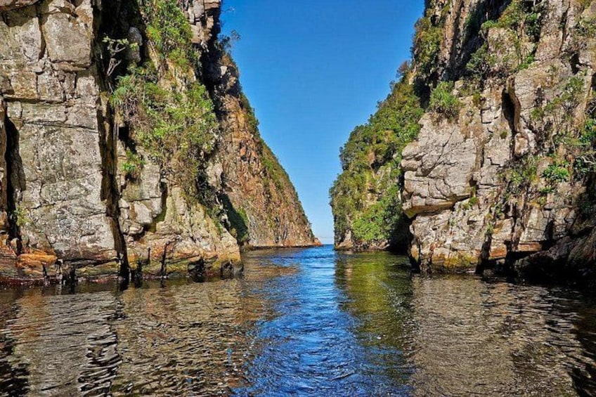 Un cañón estrecho con agua corriendo entre paredes rocosas empinadas. 2