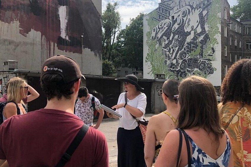A group of people gathered around a mural on a building. 1