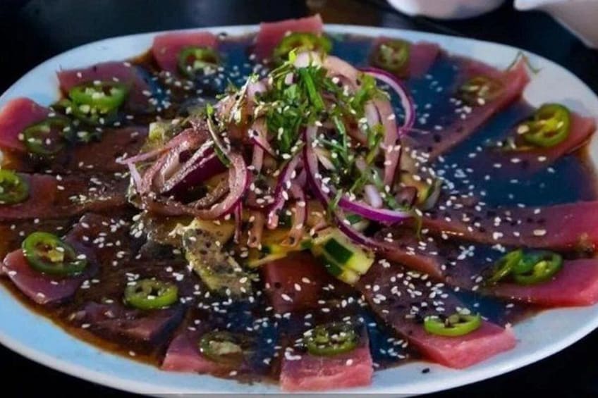 En tallerken med sashimi, forskellige toppings og en mørk sovs. 2